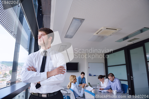 Image of business man  on a meeting in offce with colleagues in backgroun