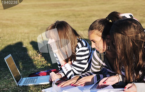 Image of group of teens working on laptop outdoor