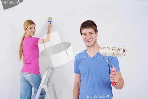 Image of happy couple paint wall at new home