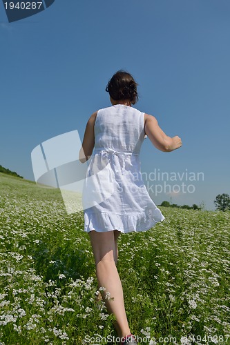 Image of Young happy woman in green field
