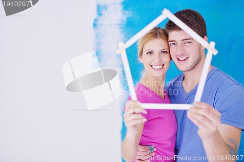 Image of happy couple paint wall at new home