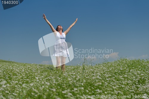Image of Young happy woman in green field