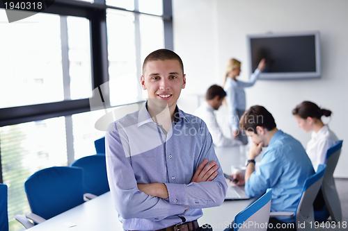 Image of business man  on a meeting in offce with colleagues in backgroun