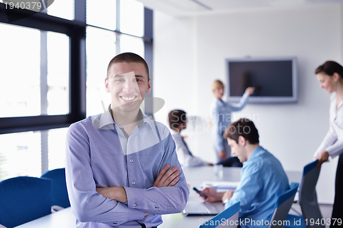 Image of business man  on a meeting in offce with colleagues in backgroun