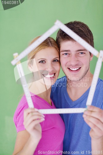 Image of happy couple paint wall at new home