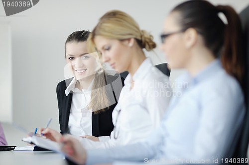 Image of business woman standing with her staff in background