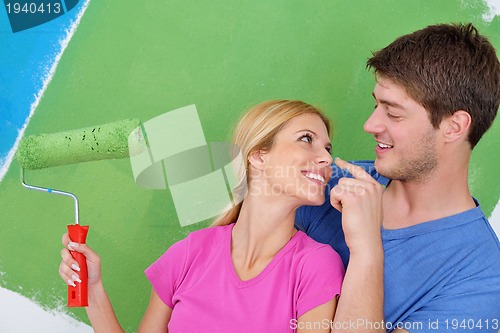 Image of happy couple paint wall at new home