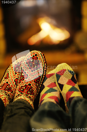 Image of Young romantic couple relax on sofa in front of fireplace at hom