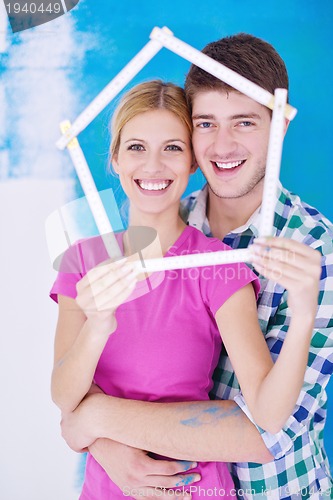 Image of happy couple paint wall at new home