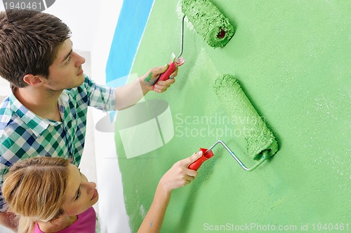 Image of happy couple paint wall at new home