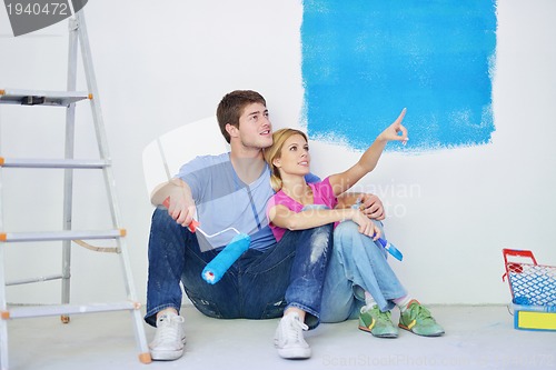 Image of happy young cople relaxing after painting in new home