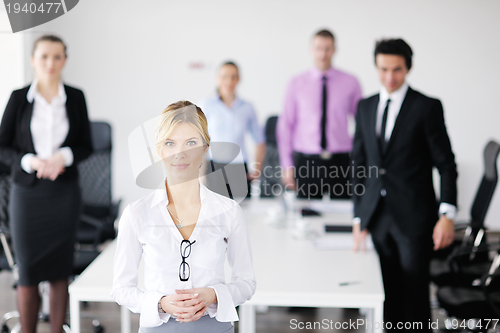 Image of business woman standing with her staff in background