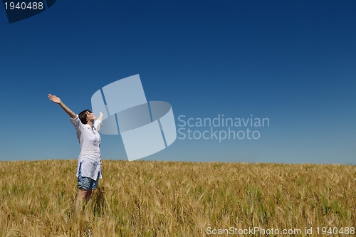 Image of young woman in wheat field at summer