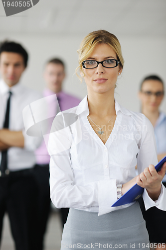 Image of business woman standing with her staff in background