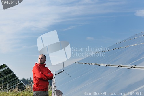 Image of engineer using laptop at solar panels plant field