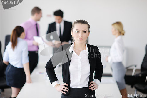 Image of business woman standing with her staff in background