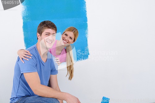 Image of happy couple paint wall at new home