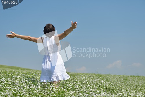 Image of Young happy woman in green field