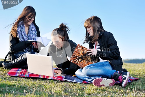 Image of group of teens working on laptop outdoor
