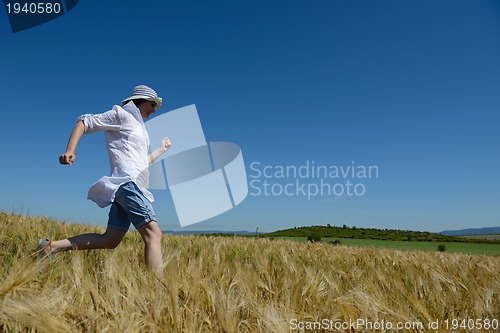 Image of young woman in wheat field at summer