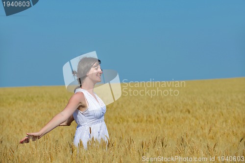 Image of young woman in wheat field at summer