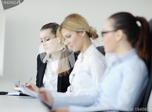 Image of business woman standing with her staff in background