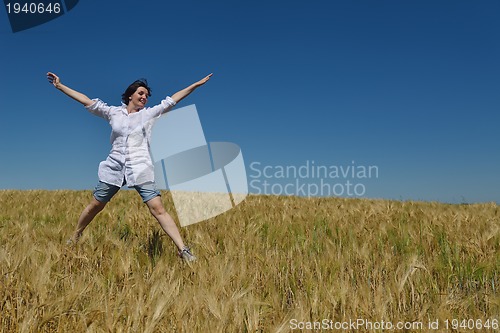 Image of young woman in wheat field at summer