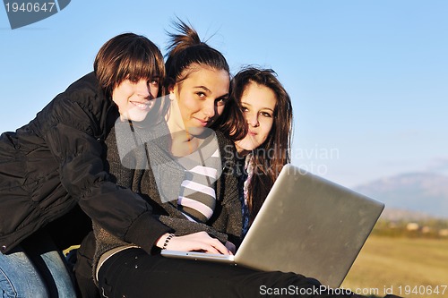 Image of group of teens working on laptop outdoor