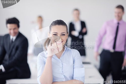 Image of business woman standing with her staff in background