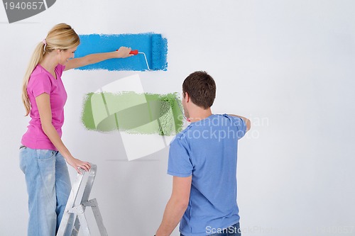 Image of happy couple paint wall at new home