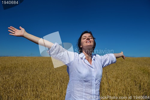 Image of young woman in wheat field at summer