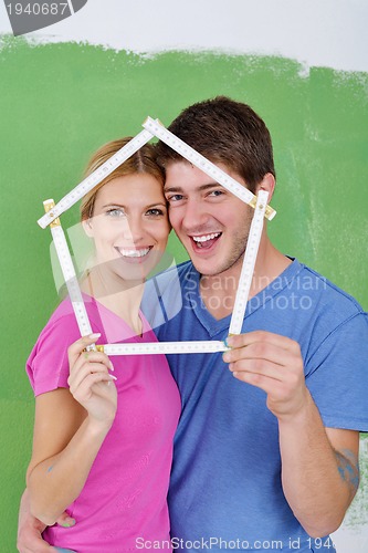 Image of happy couple paint wall at new home