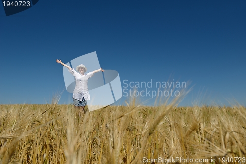 Image of young woman in wheat field at summer