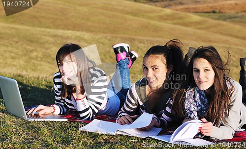 Image of group of teens working on laptop outdoor