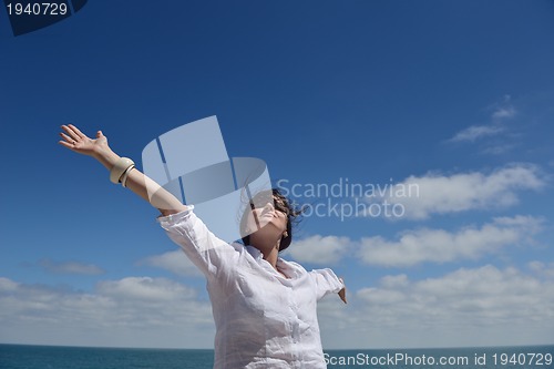 Image of happy young woman with spreading arms to sky