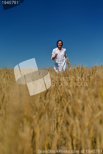 Image of young woman in wheat field at summer