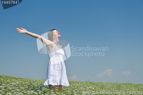 Image of Young happy woman in green field