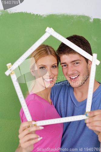 Image of happy couple paint wall at new home