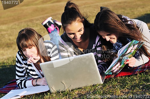 Image of group of teens working on laptop outdoor