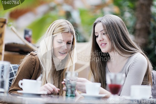 Image of cute smiling women drinking a coffee