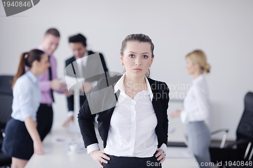 Image of business woman standing with her staff in background