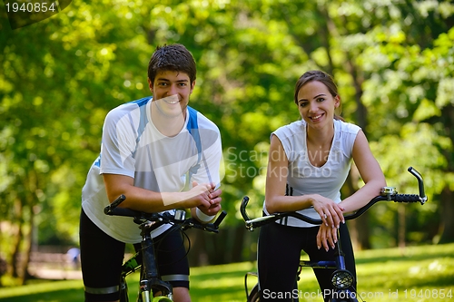 Image of Happy couple ridine bicycle outdoors