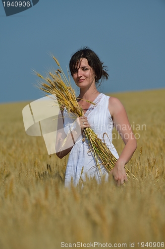 Image of young woman in wheat field at summer