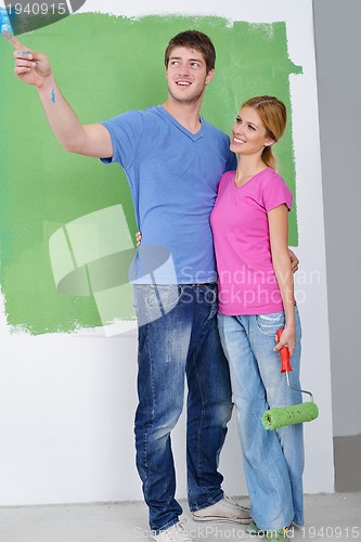 Image of happy couple paint wall at new home