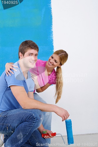 Image of happy couple paint wall at new home