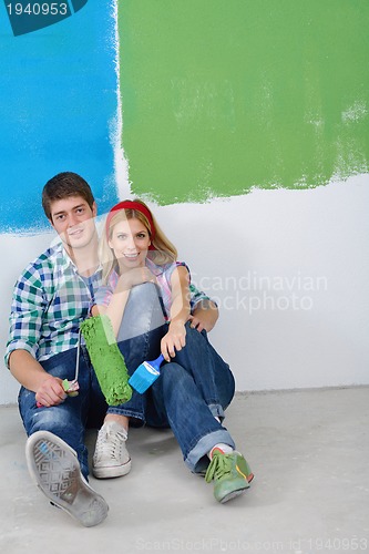 Image of happy couple paint wall at new home