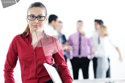 Image of business woman standing with her staff in background