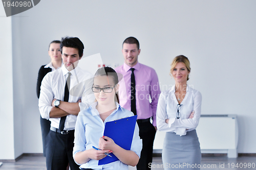 Image of business woman standing with her staff in background