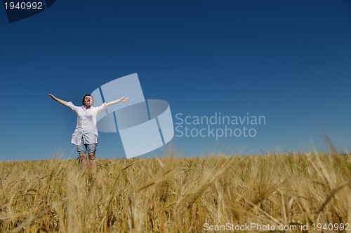 Image of young woman in wheat field at summer