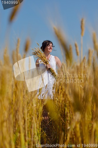 Image of young woman in wheat field at summer